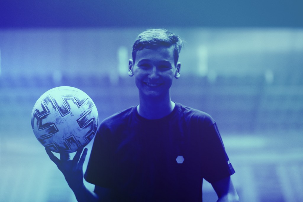 Porträtaufnahme eines jugendlichen Spielers mit Ball in seiner rechten Hand