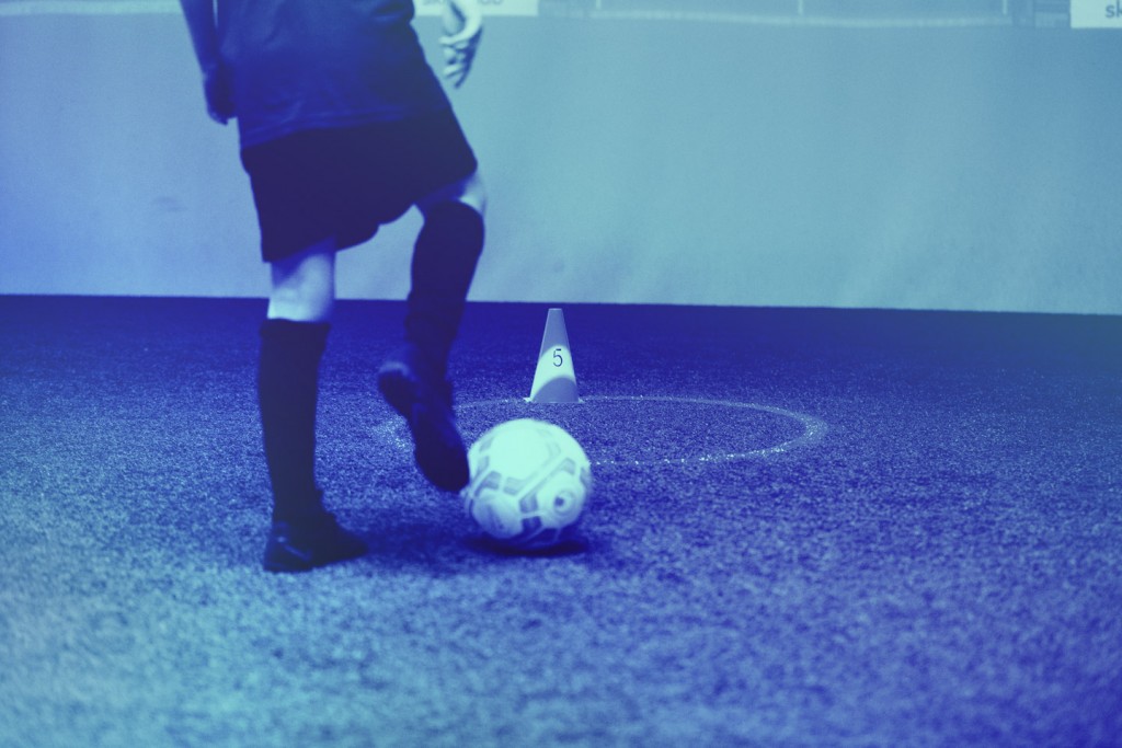 Detailaufnahme eines Kindes das einen Ball an seinem rechten Fuß führt