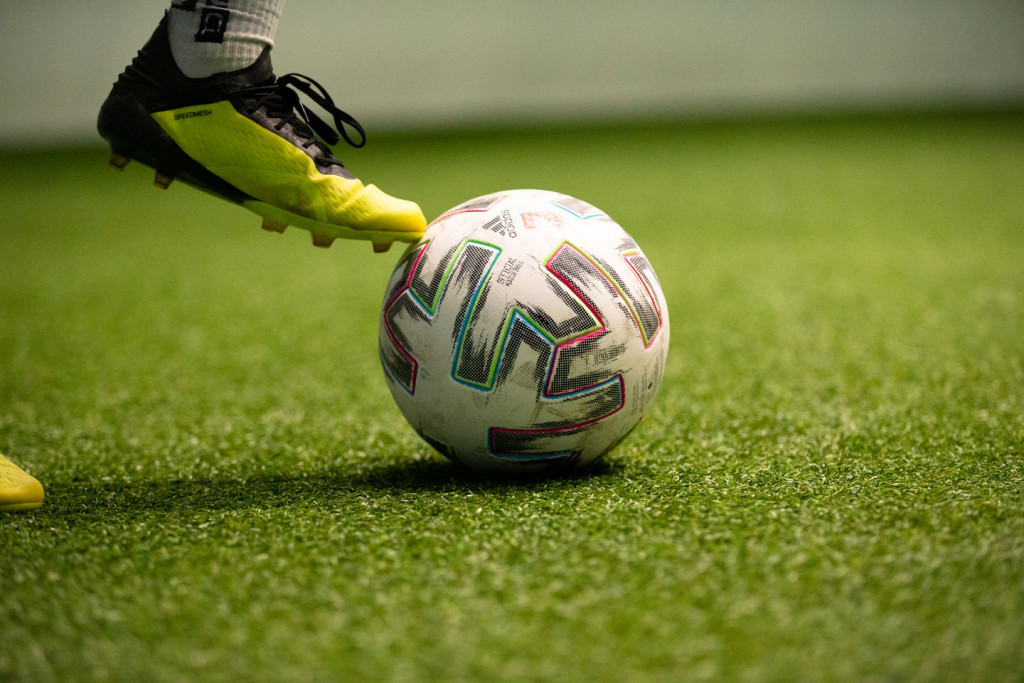 Detailaufnahme eines Spielerbeins und eines Balls