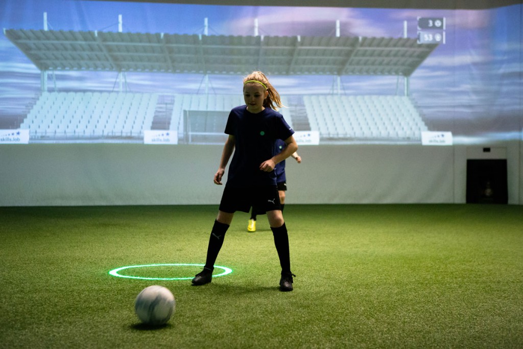 Academy - Ein junges Mädchen bei einer Passübung in der skills.lab Arena