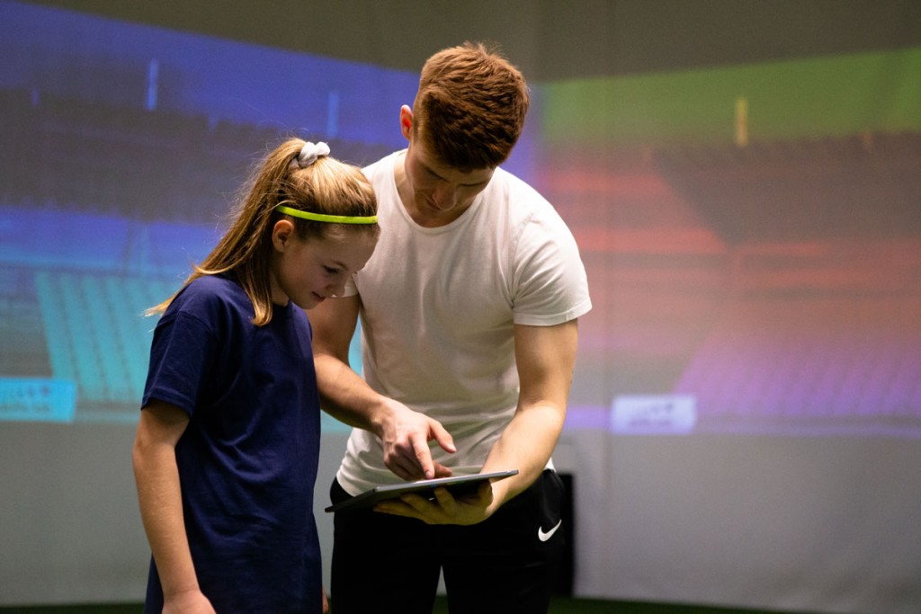 Skills Check Kinder - Ein skills.lab Coach gibt Anweisungen an eine Nachwuchsspielerin